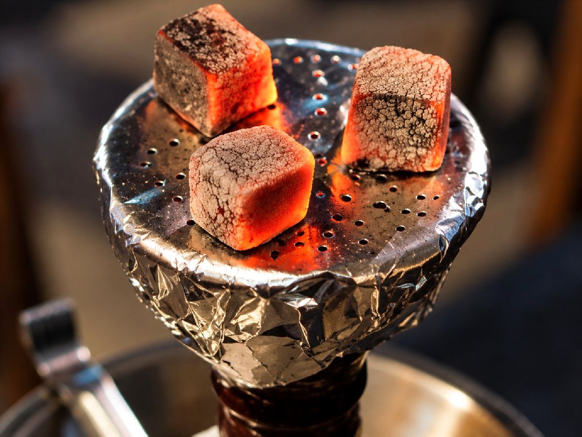 Glowing coconut shell charcoal cubes on a hookah bowl