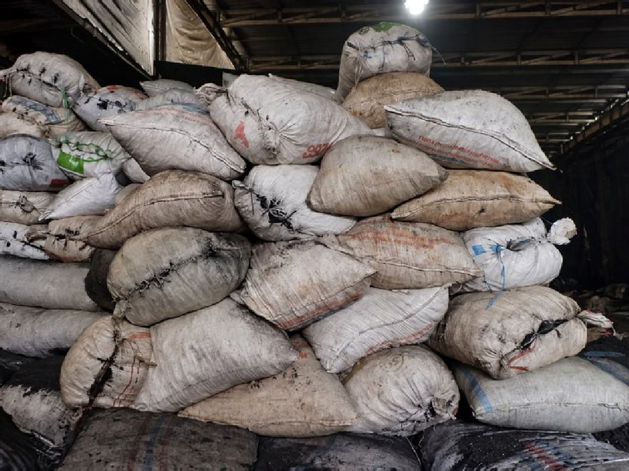 Sacks of coconut shell charcoal raw material in a warehouse