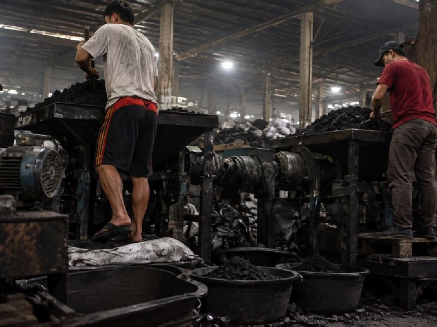 Workers operating grinding and mixing machines