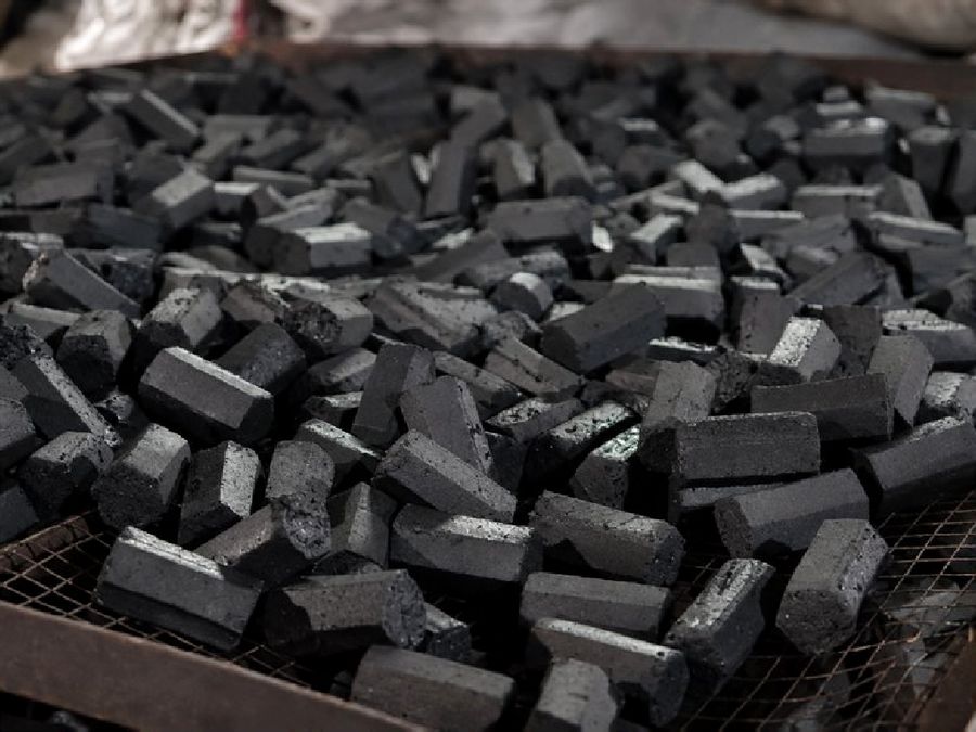 Finished charcoal briquettes on a sorting rack